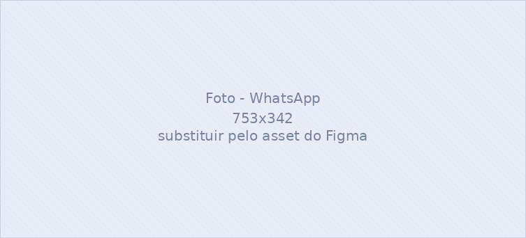 Pessoa usando o WhatsApp no celular ao lado de um notebook